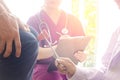 Close Ã¢â¬â up doctor and male patient.Doctor using examining patient knee jerk reflex with nurse note it Royalty Free Stock Photo